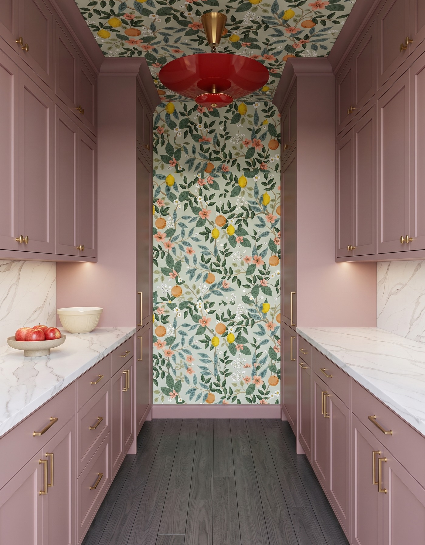 Pantry with dusty mauve cabinets, citrus-and-floral wallpaper, white diagonal gray-veined counter, dark gray-brown floor and red pendant.