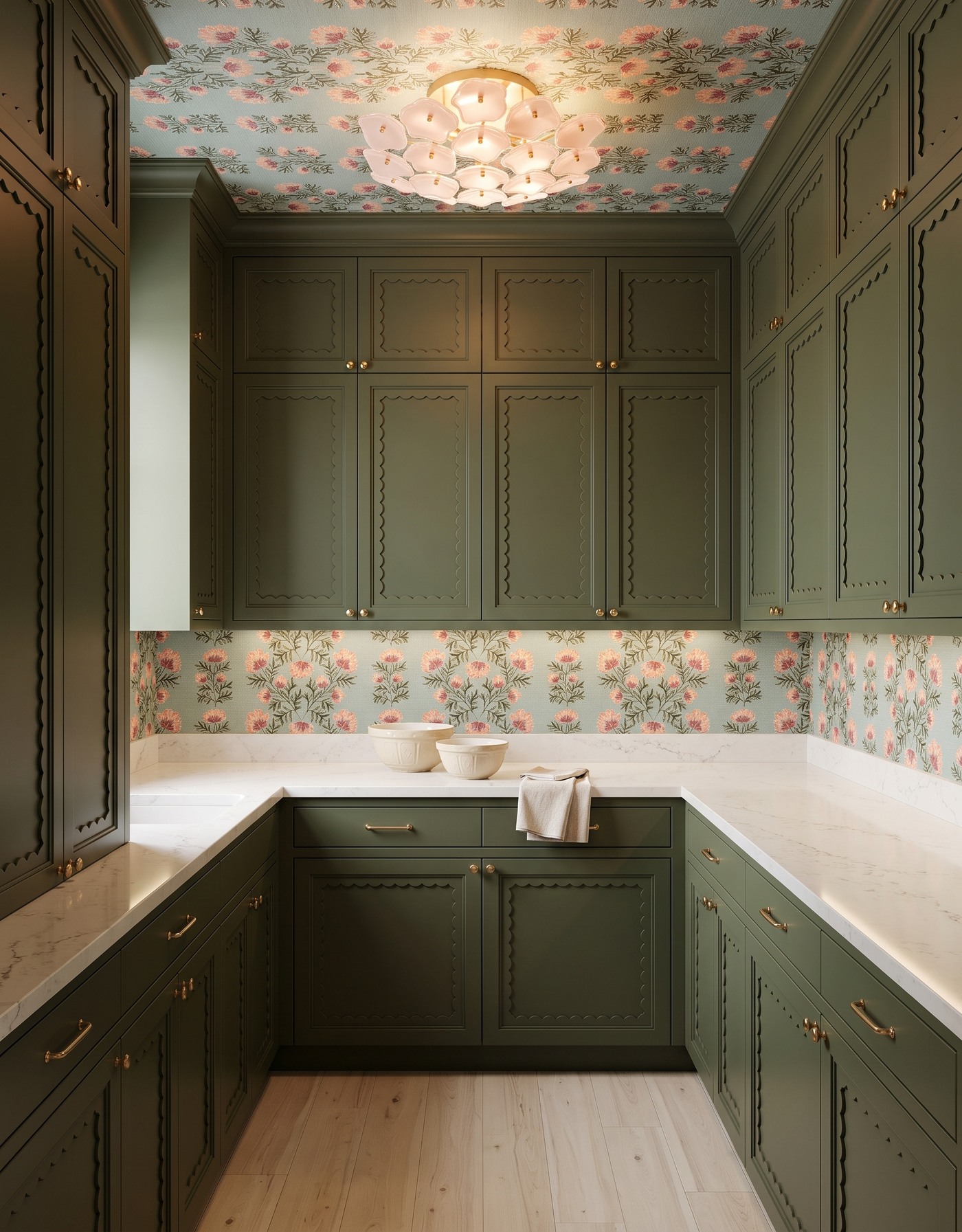 Pantry with olive scalloped cabinets, aqua-and-coral floral wallpaper, cream counter, pale wood floor and blush floral light.