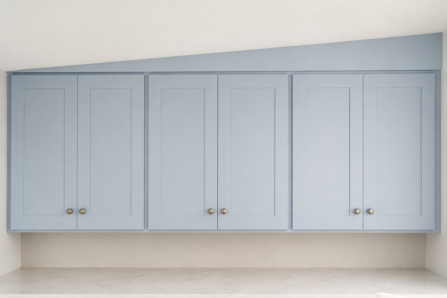 Level blue upper cabinets with a clearly visible tapered filler panel resolving an uneven ceiling above.