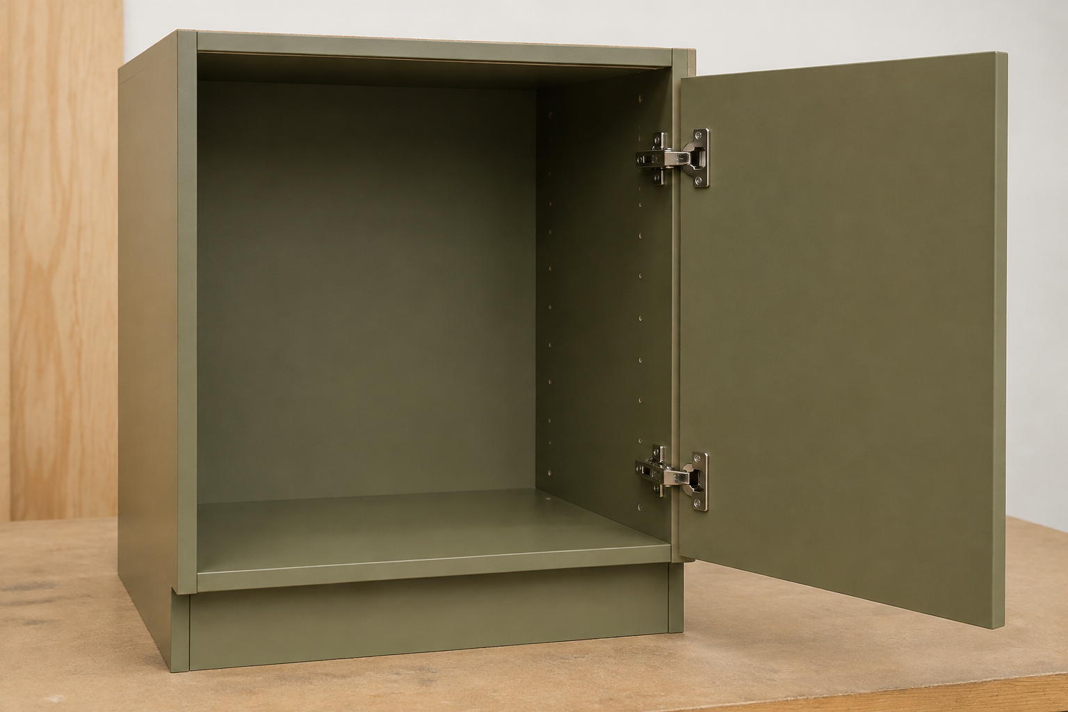 Complete empty muted-olive frameless base cabinet with a solid slab door attached directly to the cabinet side by two concealed hinges.