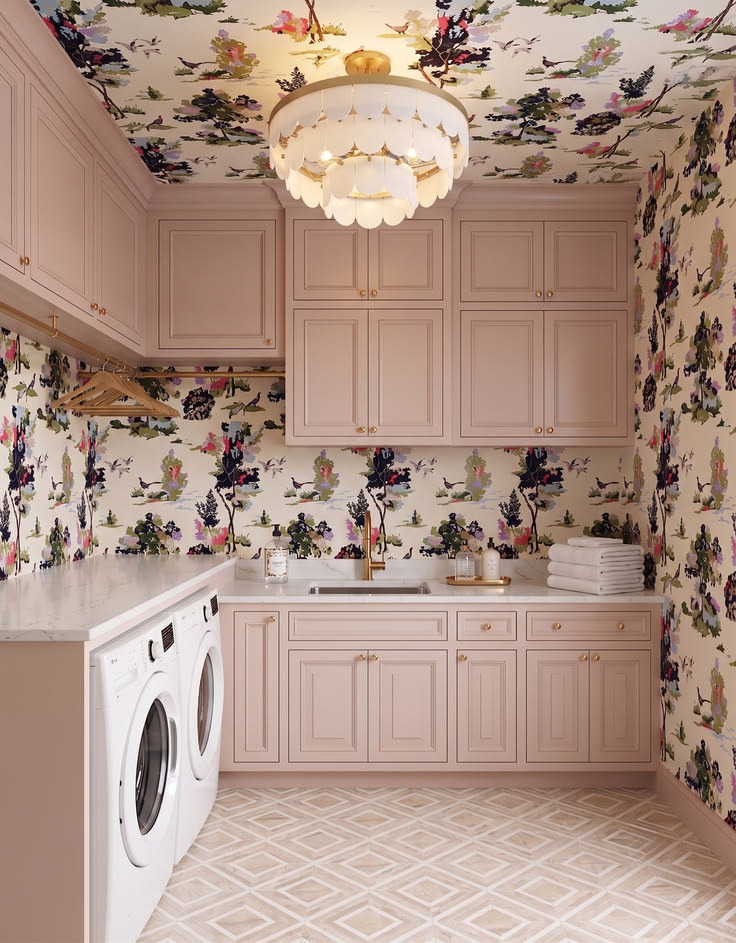 Compact blush laundry wall with concealed storage, side-by-side machines, and floral wallpaper.