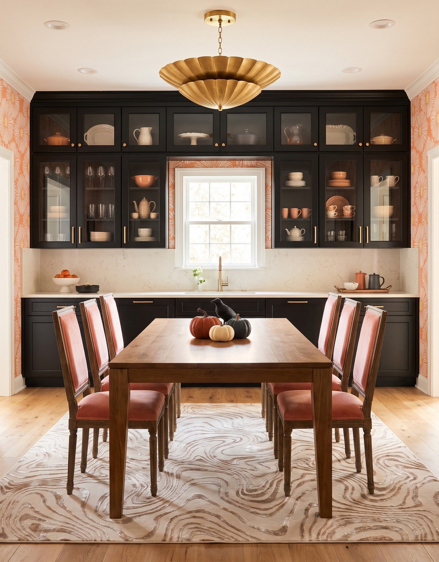 AI-created concept: Black cabinetry with peach daisies, coral chairs and a wood table styled with pumpkins and a black bird.