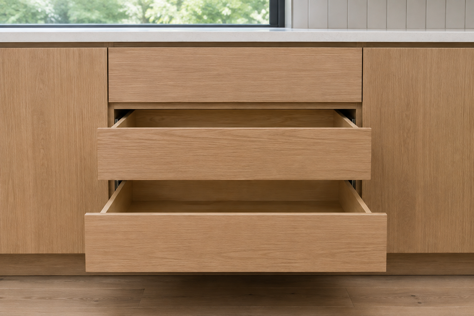 Complete straight natural-oak drawer base with one closed top drawer and two lower drawer boxes extended on paired slides.