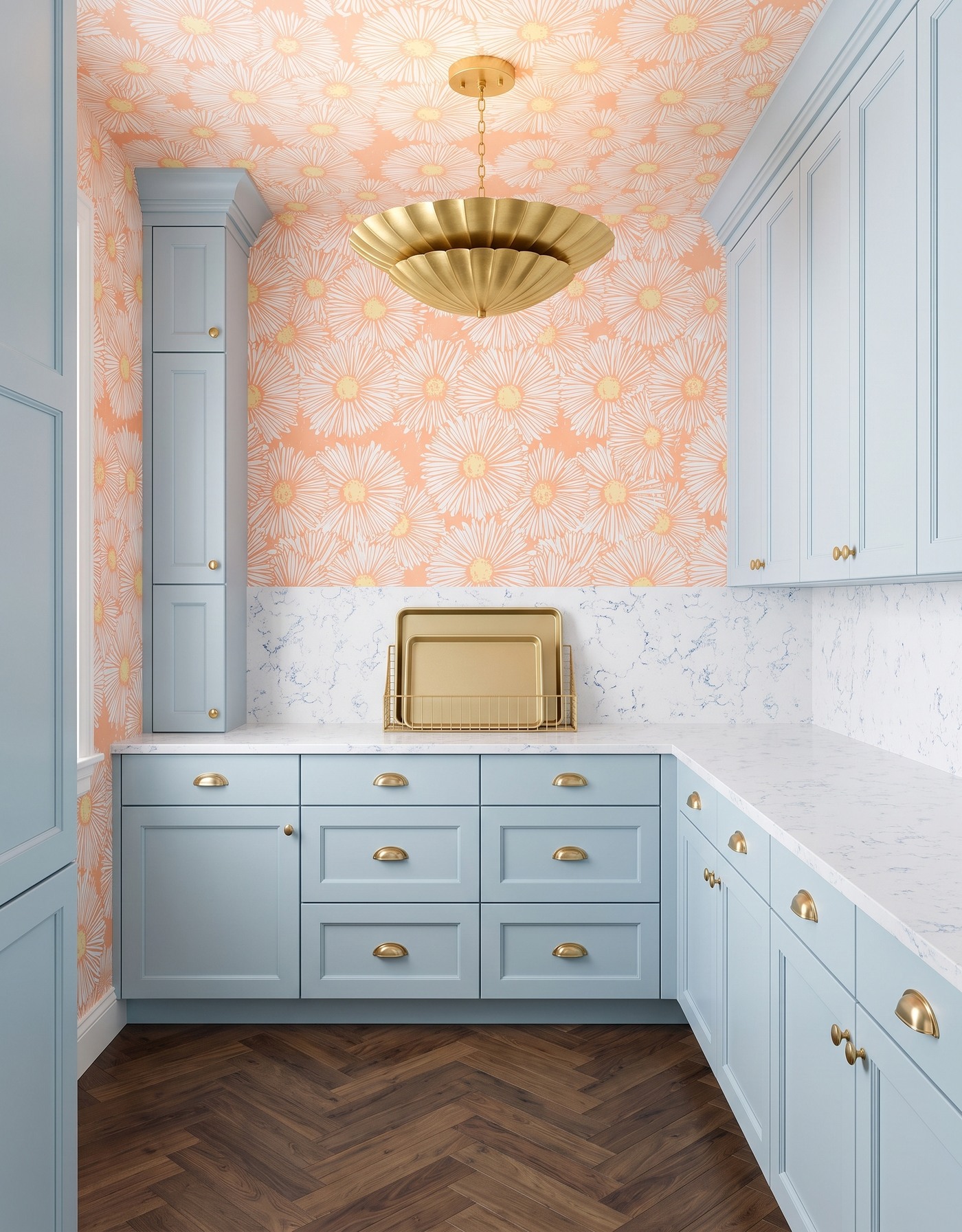 Pantry with pale blue cabinets, peach-and-ivory large floral wallpaper, white fine gray-veined counter, herringbone wood floor and brass scalloped light.