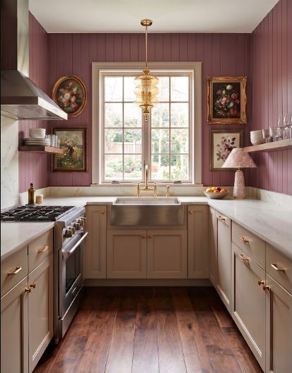 Cottage kitchen with berry-toned cabinets, beadboard details, and warm rose walls.