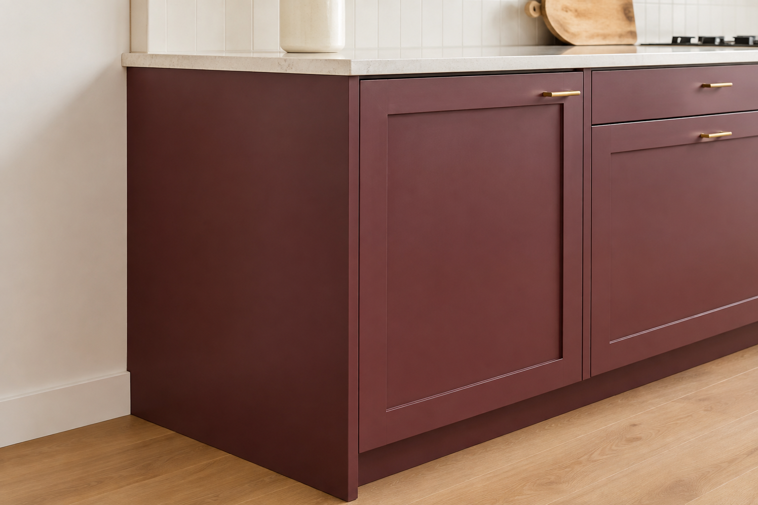 Room-facing fixed burgundy cabinet end panel with no hardware beside the closed solid door on the working front of the cabinet.