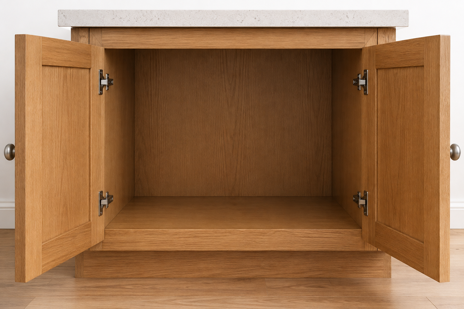 Empty pale-oak appliance cabinet with two solid doors open on two visible hinges per door and knobs at the opening edges.