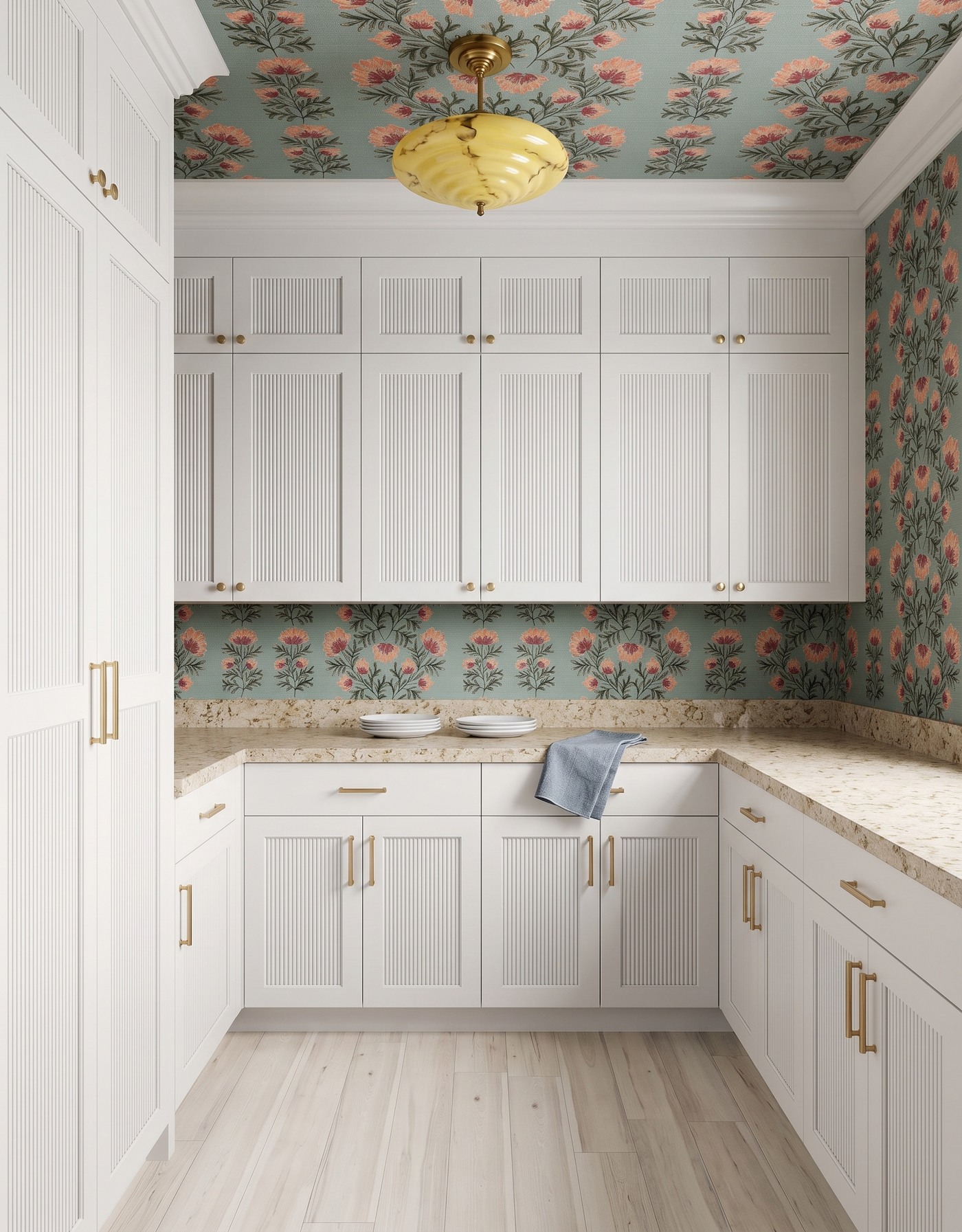 Pantry with white reeded cabinets, aqua-and-coral floral wallpaper, warm mottled cream counters, whitewashed wood floor and yellow marbled-glass light.