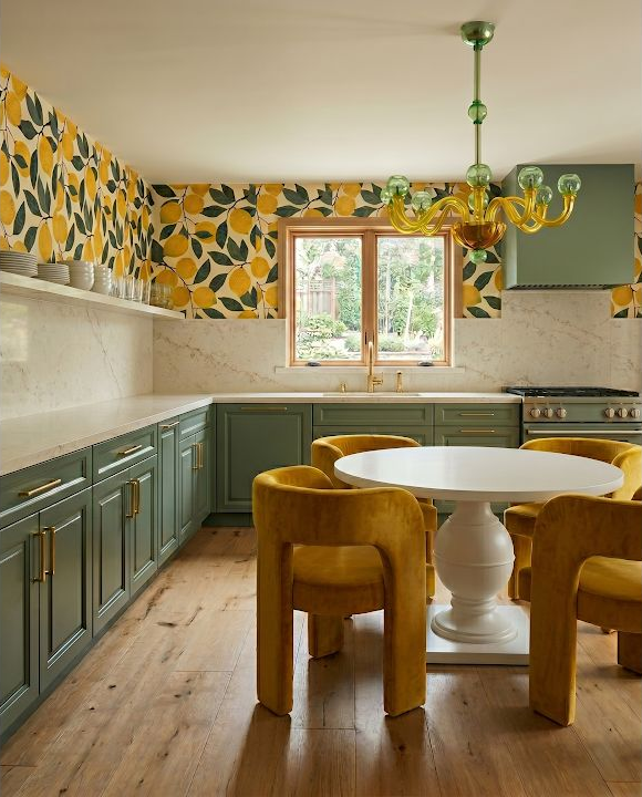 Concept image of a yellow and green kitchen with a small dining table, patterned walls, and a sculptural chandelier.