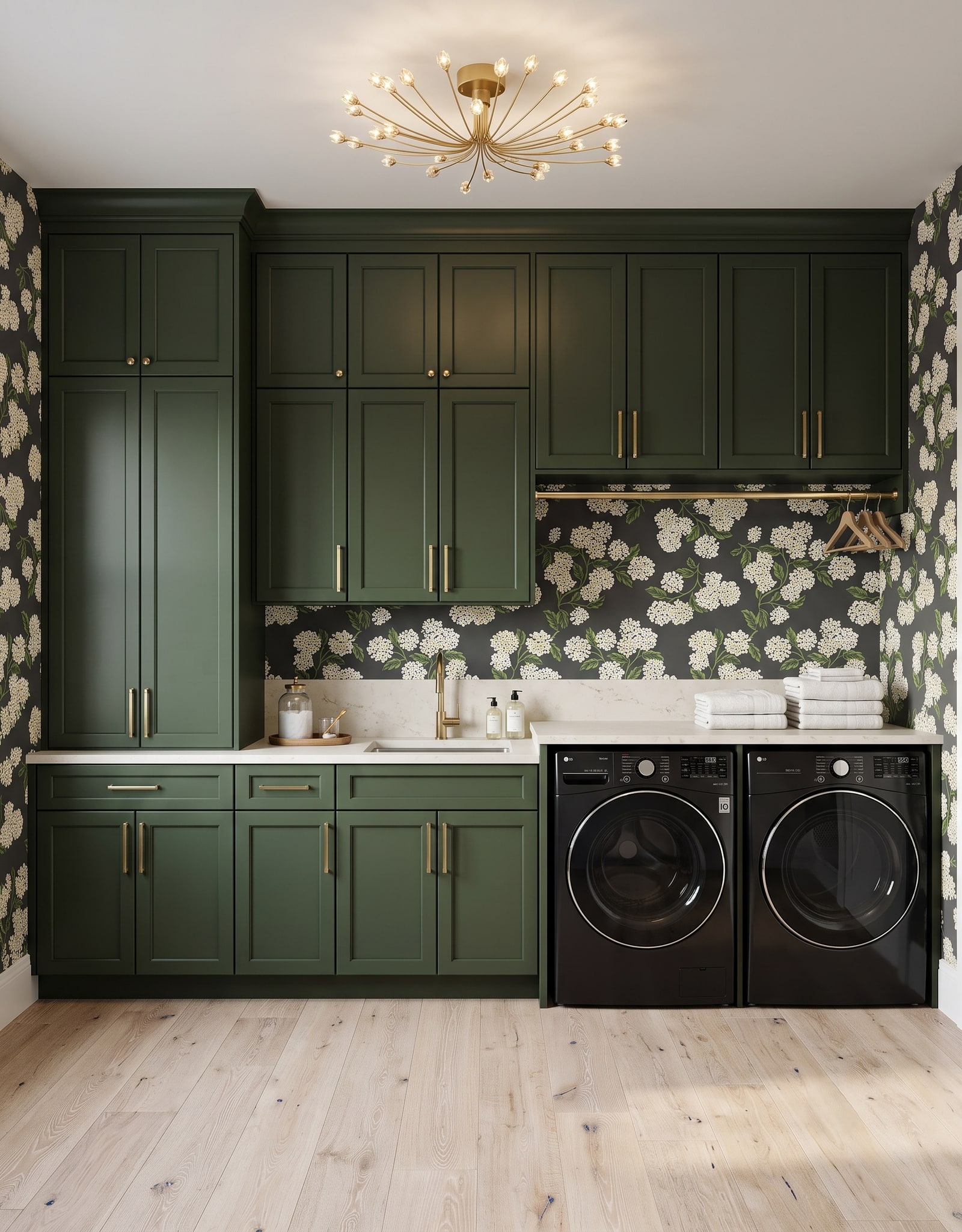A dark-green laundry wall with a sink, tall and upper storage, a front-load pair, a hanging rod, and clear floor in front.