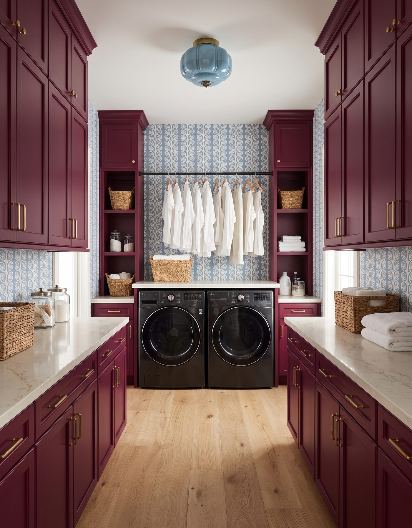 AI-created concept: Berry laundry cabinets, blue-and-cream leafy wallpaper and a pale-blue glass light above black front-loading machines.