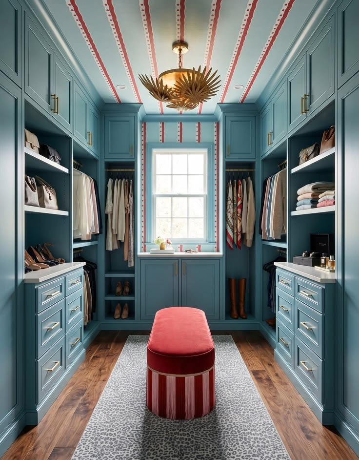 Caribbean-blue walk-in closet with red bench, closed drawers, and open hanging.