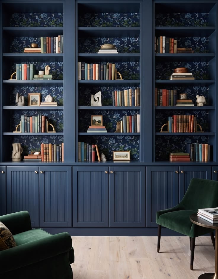 Deep navy bookcase cabinetry with dark floral shelf backs and closed storage below.