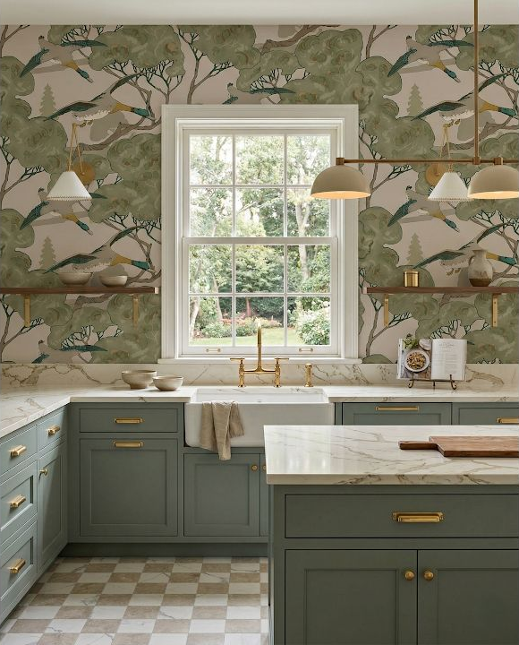 Concept image of a compact kitchen with bird-pattern wallpaper, muted green cabinets, pale counters, and a checkerboard floor.