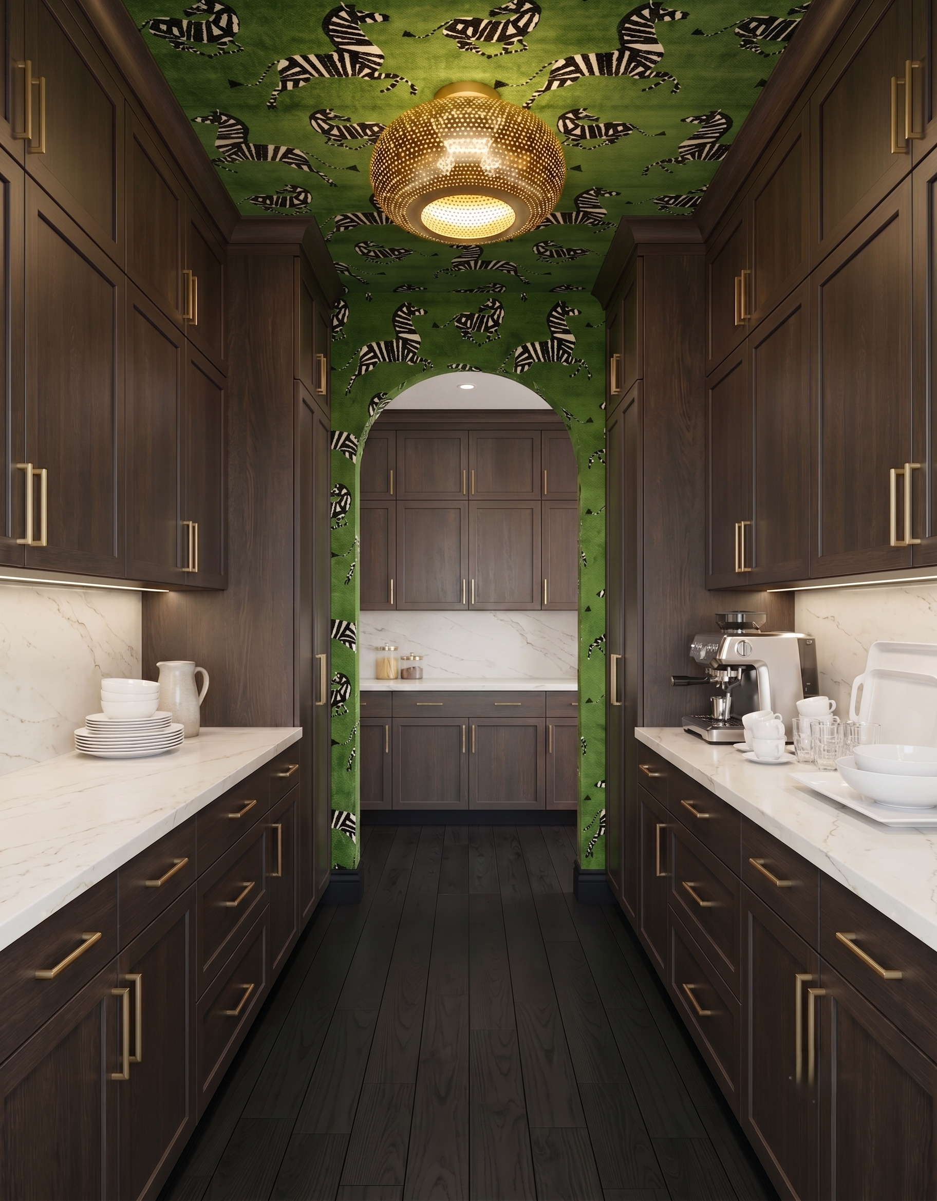 Dark-wood pantry with green zebra wallpaper across the ceiling and an arched opening, pale veined counters and a perforated brass-colored light.