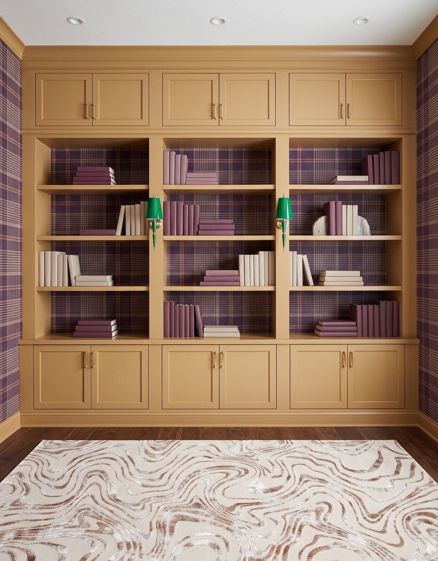 Library with ochre framed cabinets, plum-and-tan plaid wallpaper, warm brown wood floor, cream-and-taupe contour rug, green tapered sconces and plum-and-ivory books.